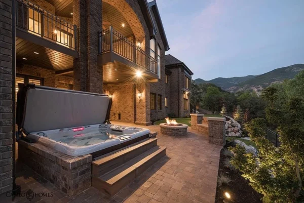 Outdoor hot tub beside mountain home and fire pit from High Elevation Hot Tubs
