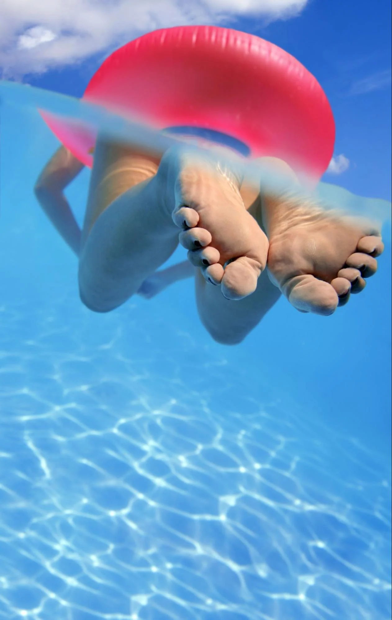 Swimmer floating with a pink ring in clear blue water, from High Elevation Hot Tubs