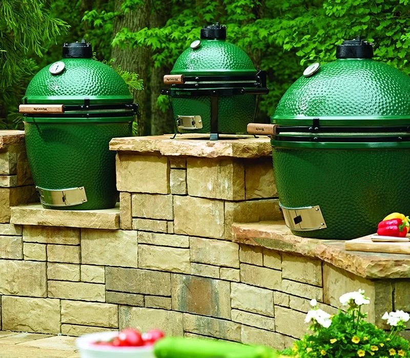 Three Big Green Egg® grills on stone outdoor kitchen counters from High Elevation Hot Tubs